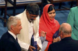 Norway's King Harald speaks to Nobel Peace Prize laureates Satyarthi and Yousafzai during the Nobel Peace Prize awards ceremony at the City Hall in Oslo